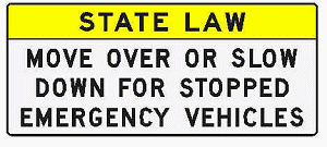 "State law. Move over or slow down for stopped emergency vehicles" sign
